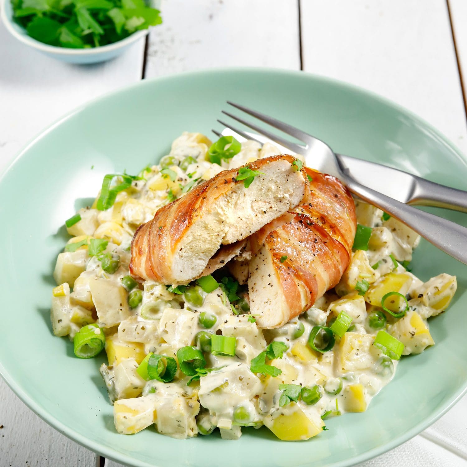 Hähnchen im Speckmantel auf cremigen Frühlingsgemüse